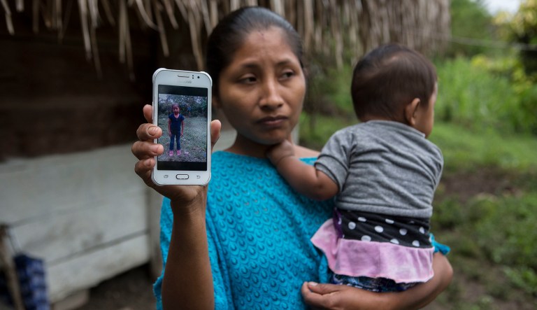 Claudia Maquin, 27, shows a photo of her daughter, Jakelin Amei Rosmery Caal Maquin in Raxruha, Guatemala, on Saturday, Dec. 15, 2018. The 7-year-old girl died in a Texas hospital, two days after being taken into custody by border patrol agents in a remote stretch of New Mexico desert.