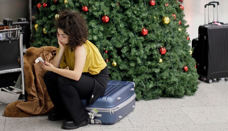A woman waits in the departures area at Gatwick airport, near London, as the airport remains closed with incoming flights delayed or diverted to other airports, after drones were spotted over the airfield last night and this morning on Thursday.