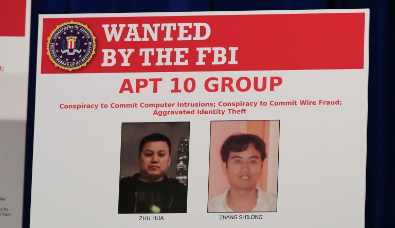 A poster displayed during a news conference at the Department of Justice in Washington, Thursday, Dec. 20, 2018, shows two Chinese citizens suspected to be with the group AP 10 carrying out an extensive hacking campaign to steal data from U.S. companies. The Justice Department is charging two Chinese citizens with carrying out an extensive hacking campaign to steal data from U.S. companies. An indictment was unsealed Thursday against Zhu Hua and Zhang Shillong. Court papers filed in Manhattan federal court allege the hackers were able to breach the computers of more than 45 entities in 12 states.