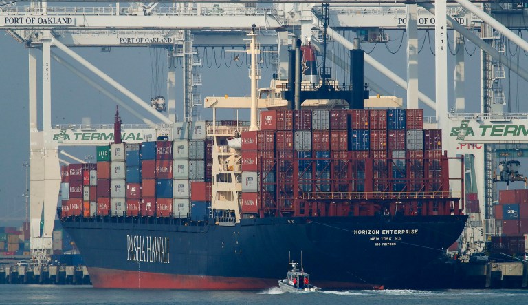 A U.S. Coast Guard vessel patrols the Oakland estuary as the container ship Horizon Enterprise is unloaded at the Port of Oakland in Oakland, Calif.