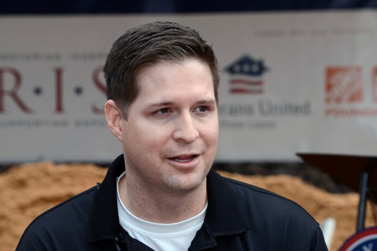 In this Jan. 14, 2016 photo, U.S. Air Force Sr. Airman (retired) Brian Kolfage, speaks with the media during a 2016 groundbreaking ceremony for a new home he and his family were receiving through the Gary Sinise Foundation's RISE program at Sandestin, Fla. An online fundraiser started by Kolfage to pay for construction of President Donald Trump's U.S.-Mexico border wall was up to millions of dollars Thursday, Dec. 20, 2018 bringing further attention to an issue that could lead to a government shutdown.