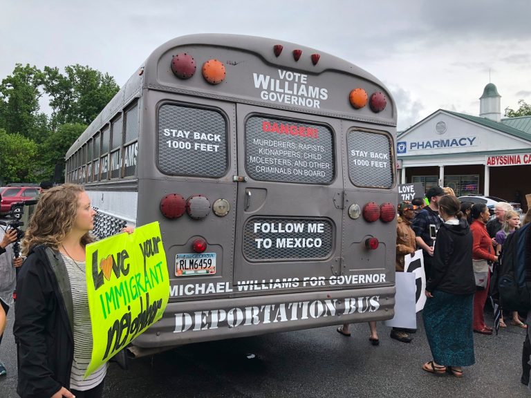 FILE - This May 16, 2018, file photo shows a vehicle used for state Sen. Michael Williams' Georgia gubernatorial election campaign, surrounded by protesters in Clarkston, Ga. Williams, a former candidate in the Georgia governor's race who featured the "deportation bus" in his GOP campaign, has been indicted on insurance fraud charges. The indictment handed up Tuesday, Dec. 20, by Hall County authorities was obtained by the Atlanta Journal-Constitution.