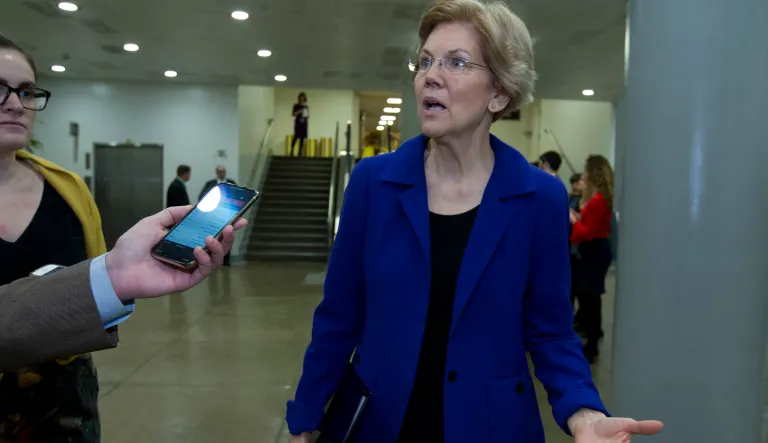 Sen. Elizabeth Warren, D-Mass., speaks to reporters on her way to her office, as the Senate takes up a House-passed bill that would pay for President Trump's border wall and avert a partial government shutdown, at the Capitol in Washington, Friday, Dec. 21, 2018.
