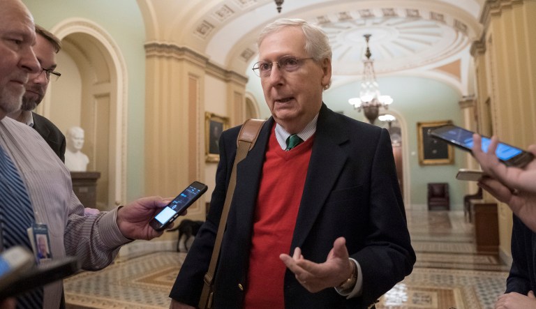 Senate Majority Leader Mitch McConnell, R-Ky., is met by reporters as he arrives at the Capitol on the first morning of a partial government shutdown.