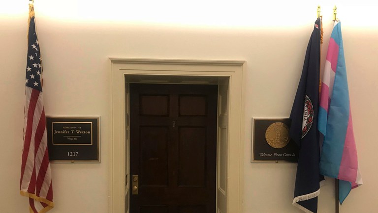 In this photo provided by the Office of Congresswoman Jennifer Wexton, a transgender pride flag, right, is displayed along with U.S., left, and Virginia, second from right, flags.
