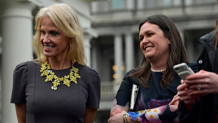 White House counselor Kellyanne Conway, left, and White House press secretary Sarah Huckabee Sanders, right, listen.