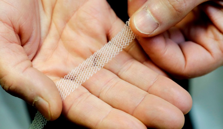 A pelvic reconstructive surgeon holds a sample of transvaginal mesh used to treat pelvic floor disorders and incontinence in women.