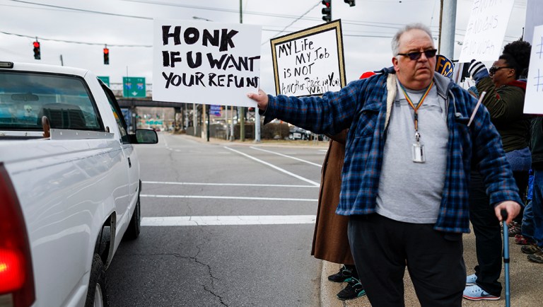 Union members and Internal Revenue Service workers rally outside an IRS Service Center.