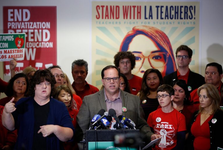 United Teachers Los Angeles president and teacher, Alex Caputo-Pearl, center at podium, announces the nation's second-largest school district will go on strike at a news conference in Los Angeles, Sunday, Jan. 13, 2019. With no new discussions scheduled, pickets are likely to begin Monday at 7 a.m. PST as teachers stand firm on sticking points including higher pay and smaller class sizes. Schools will stay open if a walkout happens. The district, with 640,000 students, has hired hundreds of substitutes to replace teachers and others who leave for picket lines.
