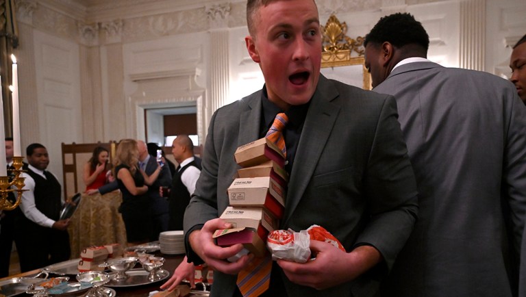 Guests attending a reception for the Clemson Tigers grab fast food sandwiches in the State Dining Room.