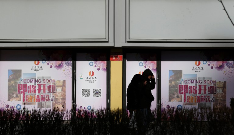 People walk by vacant retail shop lots in Beijing, Tuesday, Jan. 15, 2019. China plans to slash taxes, step up spending, and provide ample financing to private and small enterprises to help counter the country's worst slowdown since the global financial crisis and the impact of a bruising trade war with the U.S. 