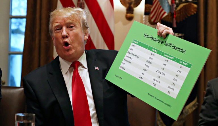 President Trump holds up examples of tariffs, Thursday, Jan. 24, 2019, in the Cabinet Room of the White House in Washington.