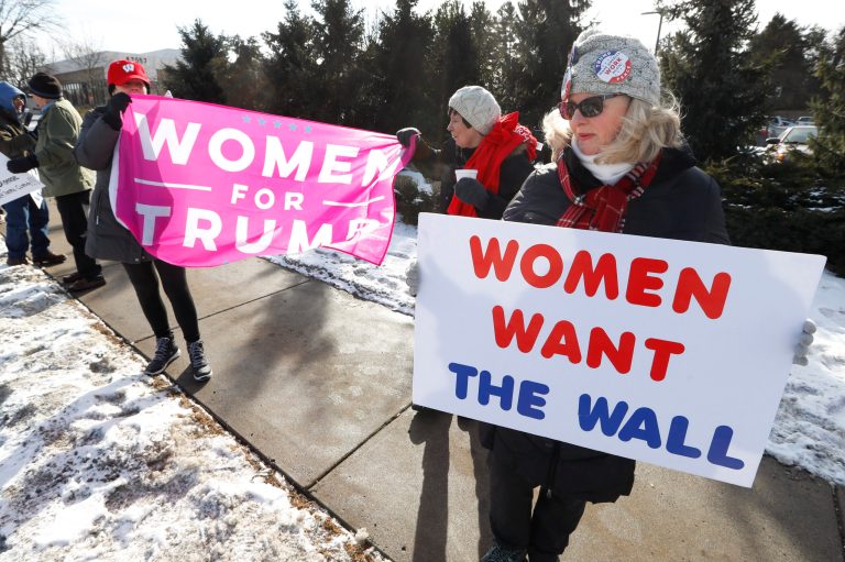 Supporters hold signs at a women for Trump "Build the Wall" rally in Bloomfield Hills, Mich., Saturday, Jan. 26, 2019.