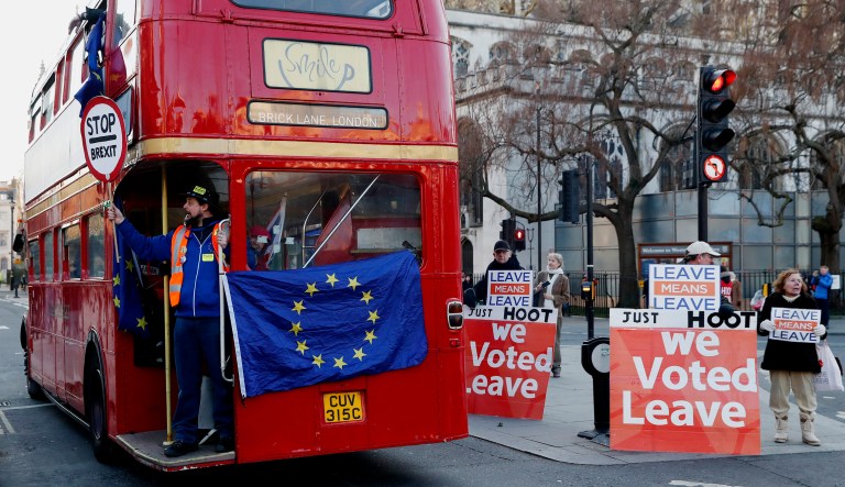 Anti-Brexit protesters on board a hired red London bus demonstrate near pro-Brexit supporters as they drive past the Houses of Parliament in London.