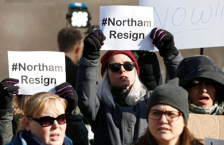 Demonstrators hold signs and chant outside the Governors Mansion at the Capitol in Richmond, Va., Saturday, Feb. 2, 2019. The demonstrators are calling for the resignation of Virginia Governor Ralph Northam after a 30-year-old photo of him on his medical school yearbook photo was widely distributed Friday.