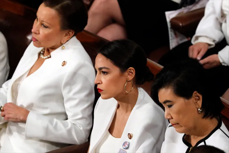 Rep. Alexandria Ocasio-Cortez, D-N.Y., center, listens as President Donald Trump delivers his State of the Union address.