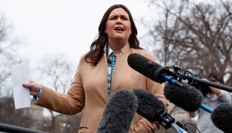 White House press secretary Sarah Sanders talks with reporters outside the White House in Washington, Friday, Feb. 15, 2019. 