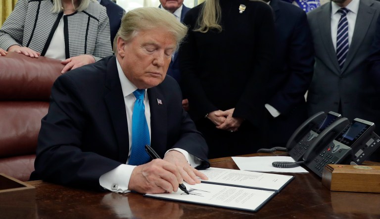 President Donald Trump signs the "Space Policy Directive 4" in the Oval Office of the White House, Tuesday, Feb. 19, 2019, in Washington.