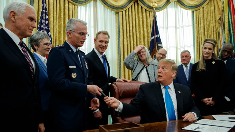 President Trump hands a pen to Air Force Gen. Paul Selva after signing "Space Policy Directive 4" in the Oval Office of the White House.