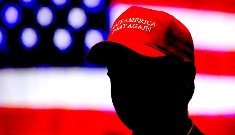 In this Nov. 6, 2018, a man wears a hat with President Trump's campaign slogan in Montgomery, Ala.