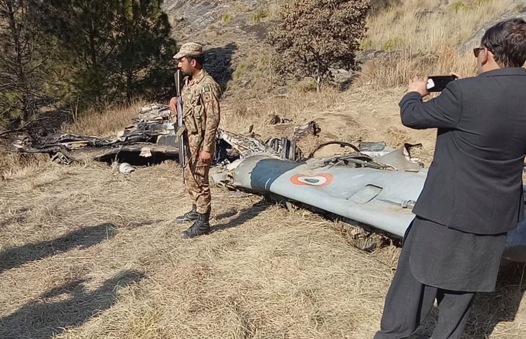 A Pakistani soldier stands guard near the wreckage of an Indian plane shot down by the Pakistan military on Wednesday, in Hurran, near the Line of Control in Pakistani Kashmir, Thursday, Feb. 28, 2019. 