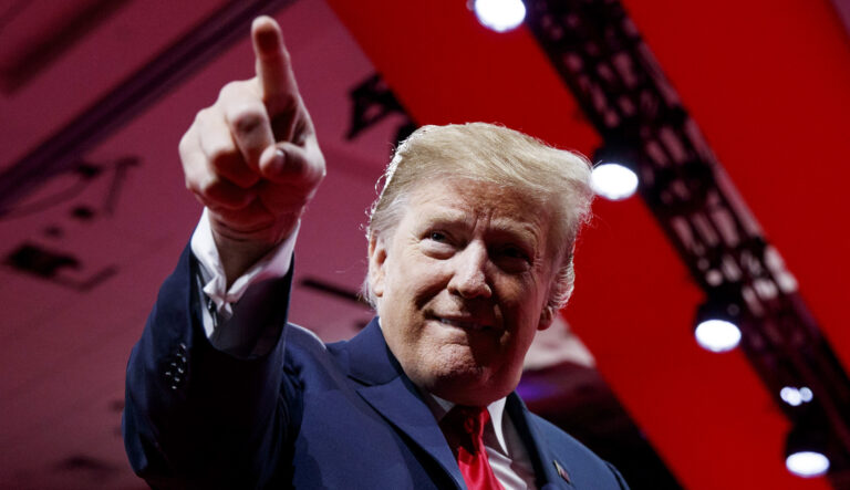 President Trump points to the cheering audience as he arrives to speak at an event.