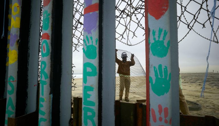 A construction worker replaces fencing lining the north side of the border wall separating San Diego from Tijuana, Mexico, Monday, March 11, 2019, seen from Tijuana. President Donald Trump is reviving his border wall fight, preparing a new budget that will seek $8.6 billion for the U.S-Mexico barrier while imposing steep spending cuts to other domestic programs.