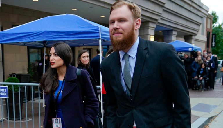 Rep.-elect Alexandria Ocasio-Cortez, D-NY., left, is seen leaving orientation session for new members of congress, Tuesday, Nov. 13, 2018, in Washington. Walking alongside Ocasio-Cortez is Riley Roberts, right.