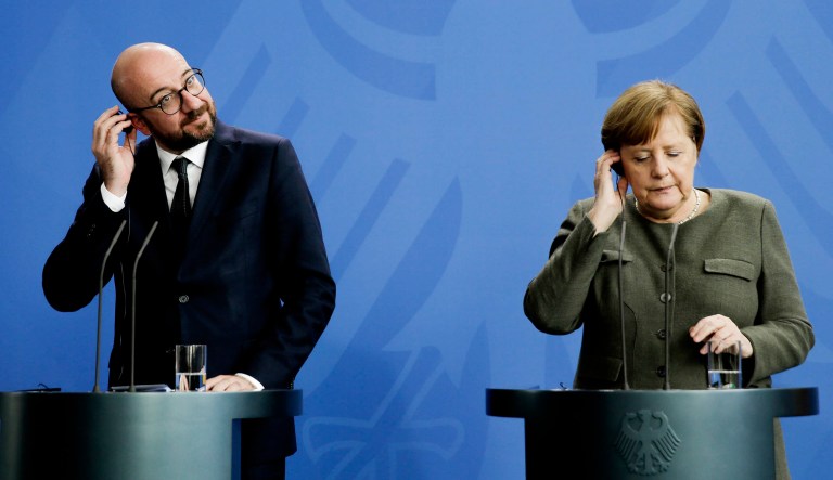 German Chancellor Angela Merkel, right, and the Prime Minister of Belgium Charles Michel, left, adjust their headphones during a news conference.