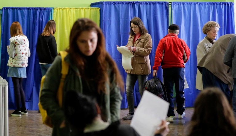 Voters prepare their ballots to cast at a polling station during the presidential election in Kiev, Ukraine, Sunday, March 31, 2019.