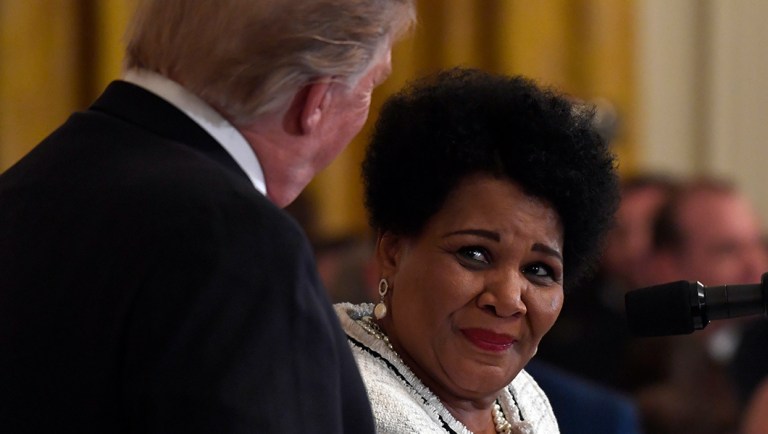 President Trump, left, listens as former prisoner Alice Johnson, right, speaks.
