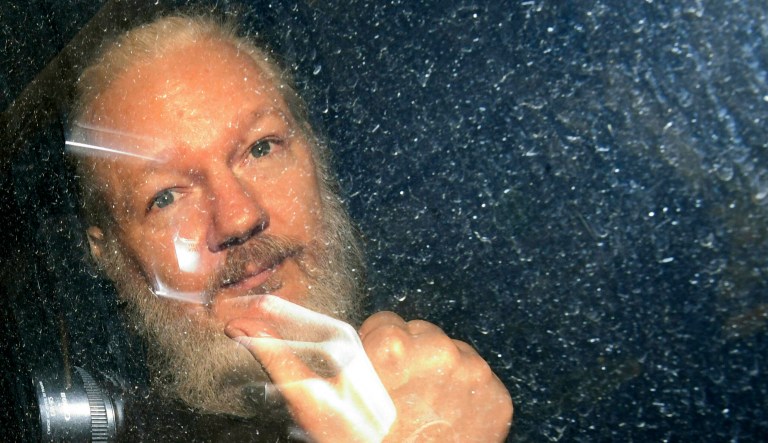 Julian Assange gestures as he arrives at Westminster Magistrates' Court in London, after the WikiLeaks founder was arrested by officers from the Metropolitan Police and taken into custody Thursday April 11, 2019. Police in London arrested WikiLeaks founder Assange at the Ecuadorean embassy Thursday, April 11, 2019 for failing to surrender to the court in 2012, shortly after the South American nation revoked his asylum.