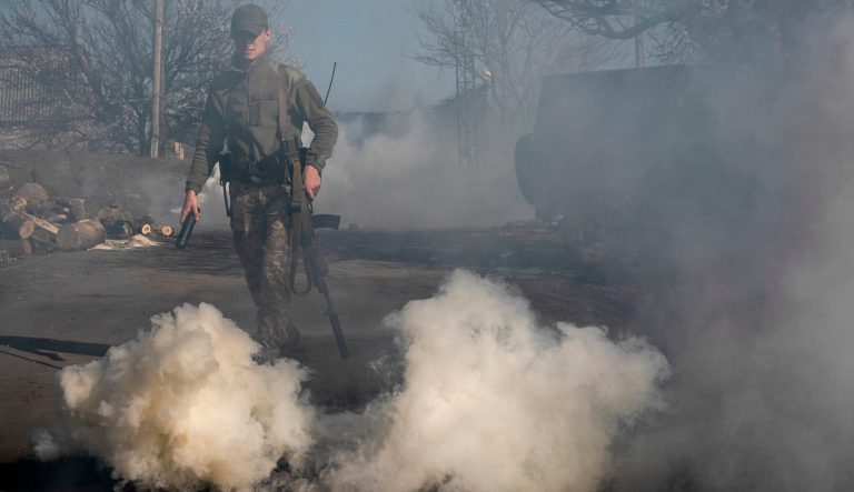 A Ukrainian serviceman makes smokescreen against military drones at a position near the front line as the conflict continues, in Mariinka, Donetsk region, eastern Ukraine, Saturday, April 20, 2019. 