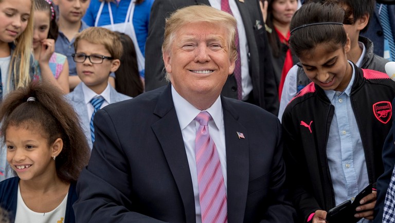 President Trump sits with children during the annual White House Easter Egg Roll.
