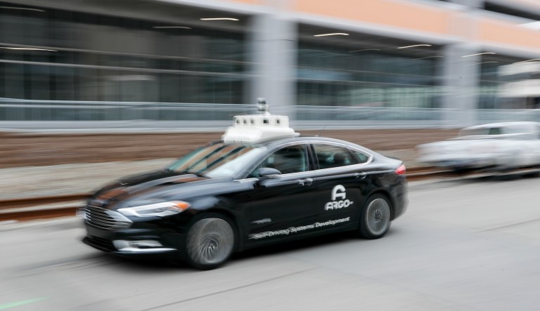 In this Jan. 4, 2019, photo made with a slow shutter speed, one of the test vehicles from Argo AI, Ford's autonomous vehicle unit, navigates through the strip district near the company offices in Pittsburgh.