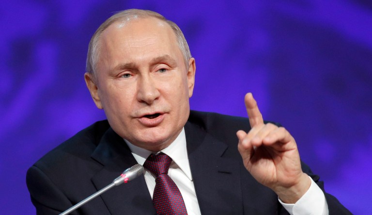 Russian President Vladimir Putin gestures while speaking.