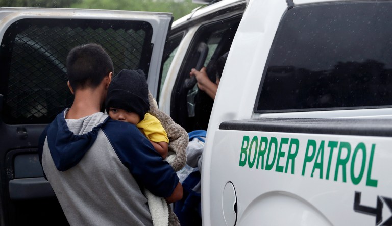 In this March 14, 2019, file photo, families who crossed the nearby U.S.-Mexico border near McAllen, Texas are placed in a Border Patrol vehicle.