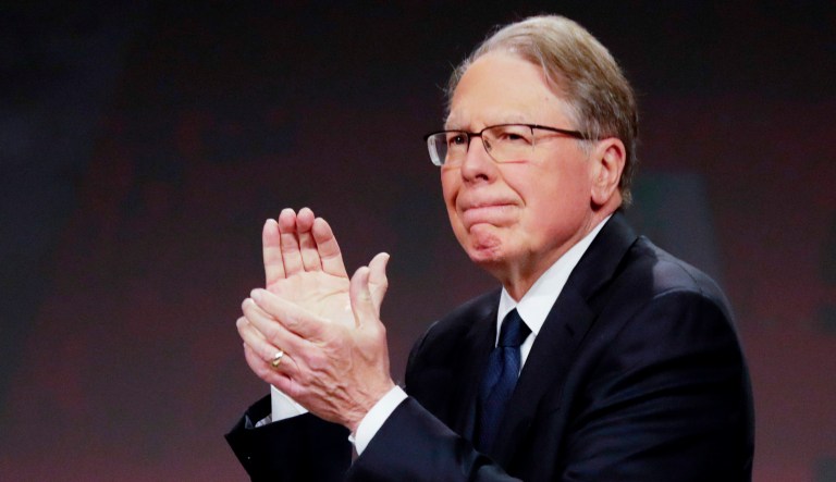 Nation Rifle Association Executive Vice President Wayne LaPierre applauds behind the empty seat of Retired Lt. Col. Oliver North at the NRA Annual Meeting of Members in Indianapolis.