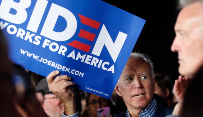 Former Vice President and Democratic presidential candidate Joe Biden holds a sign in support of his campaign.