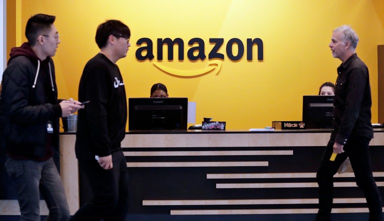 Employees walk through a lobby at Amazon's headquarters in Seattle.