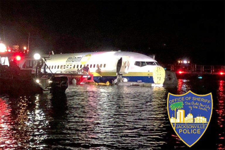 In this photo released by the Jacksonville Sheriff's Office, authorities work at the scene of a plane in the water in Jacksonville, Fla.