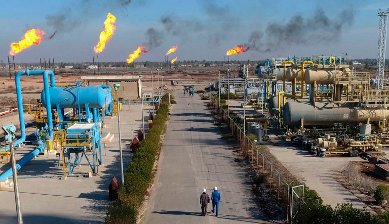 In this Thursday, Jan. 12, 2017 photo, laborers walk in the Nihran Bin Omar field north near Basra, Iraq. Prime Minister Adel Abdul-Mahdi said Tuesday, May 7, 2019 that he has instructed Iraq's Oil Ministry to finalize an agreement with global energy giants ExxonMobil and PetroChina to lead a $53 billion megaproject to boost oil production. 