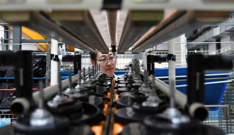 A factory worker checks parts at a manufacturing plant for automobile air conditioners in Yantai in eastern China's Shandong province, Wednesday, May 15, 2019. China's factory output and consumer spending weakened in April as a tariff war with Washington intensified, stepping up pressure on Beijing to shore up economic growth.