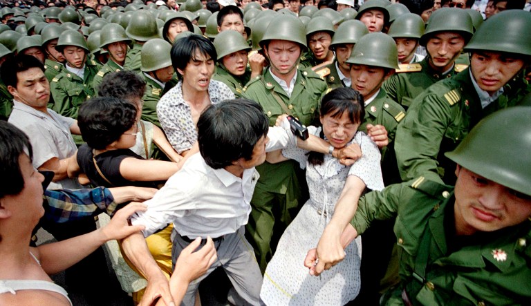 A young woman is caught between civilians and Chinese soldiers, who were trying to remove her from an assembly near the Great Hall of the People in Beijing. Over seven weeks in 1989, the student-led pro-democracy protests centered on Beijingâs Tiananmen Square became Chinaâs greatest political upheaval since the end of the decadelong Cultural Revolution more than a decade earlier.