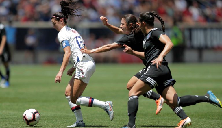 United States forward Alex Morgan, left, runs with the ball with Mexico defender Rebeca Bernal, center, and defender Greta Espinoza in tow during the first half of an international friendly soccer match, Sunday, May 26, 2019, in Harrison, N.J. 