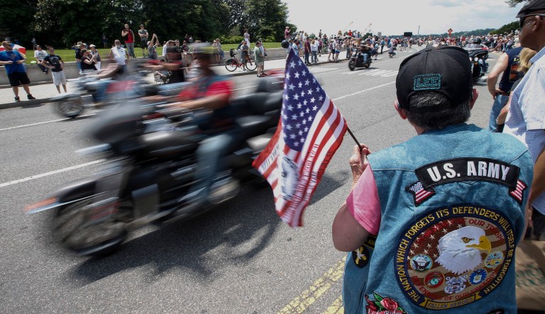 Karen Beck, from Mechanicsville, Md., a Vietnam War veteran, holds a flag as motorcyclists participate in the 32nd Rolling Thunder demonstration in D.C.