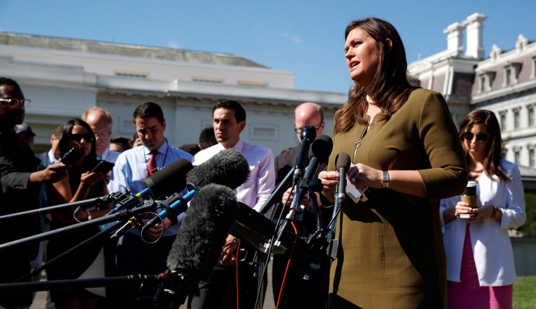 White House press secretary Sarah Sanders talks to reporters outside the White House in Washington.