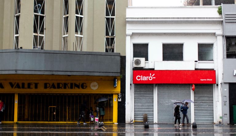 People walk in front of closed stores during a blackout, in Buenos Aires, Argentina, Sunday, June 16, 2019. Argentina and Uruguay were working frantically to return power on Sunday, after a massive power failure left large swaths of the South American countries in the dark. 