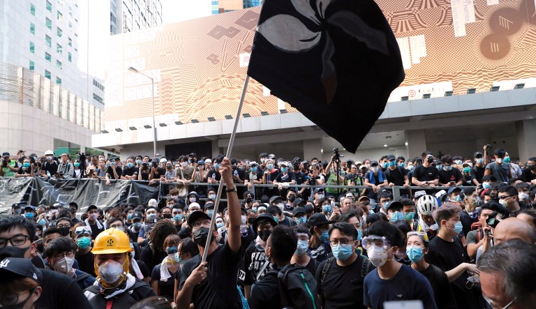 A protestor waves a black version of the Hong Kong flag outside the police headquarters in Hong Kong, Friday, June 21, 2019. More than 1,000 protesters blocked Hong Kong police headquarters into the evening Friday, while others took over major streets as the tumult over the city's future showed no signs of abating.