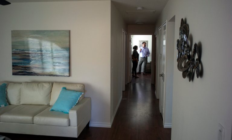 In this June 20, 2019 image, Irene Scully, left, talks with real estate agent Fred Portillo Sr., as they tour an apartment for rent in Escondido, Calif. 